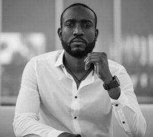 Black and white portrait of a stylish man in a white shirt indoors.